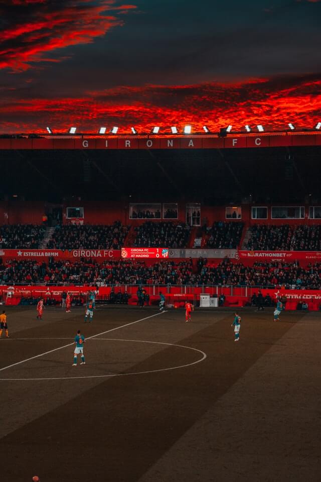 En fodboldkamp på Gironas stadion med en flot knaldrød himmel